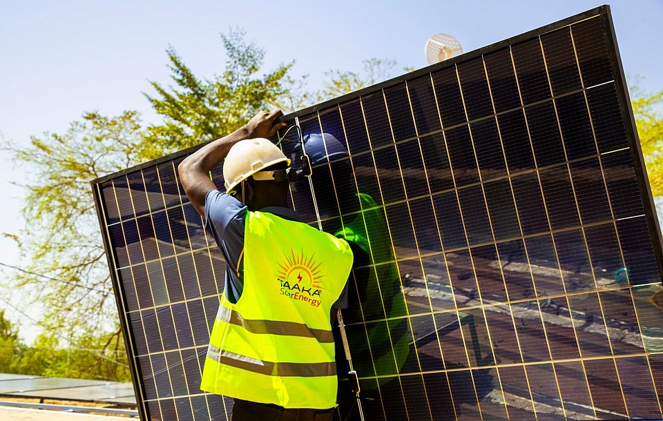 Taaka-SolarEnergy employé transportant un panneau photovoltaïque
