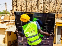 Taaka-SolarEnergy employee moving a solar panel